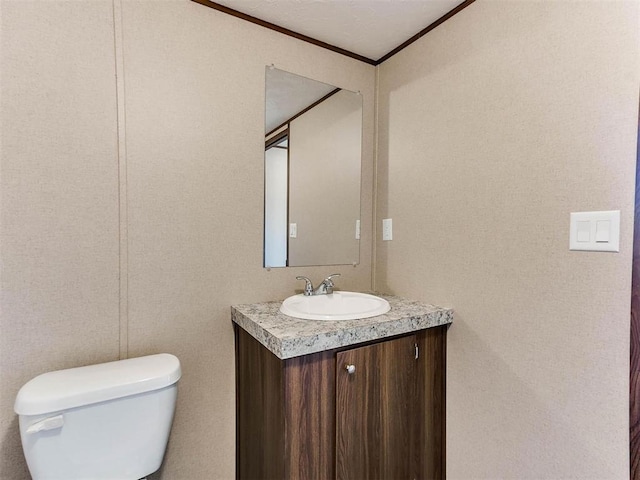 bathroom with crown molding, vanity, and toilet