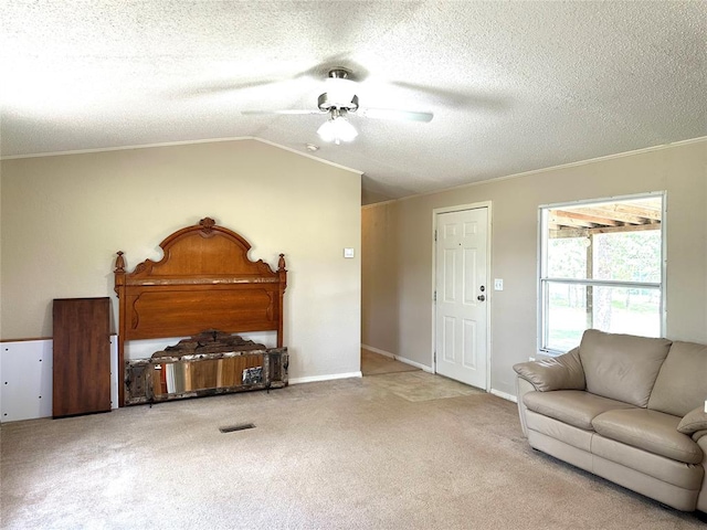 carpeted living room featuring ceiling fan, lofted ceiling, a textured ceiling, and ornamental molding