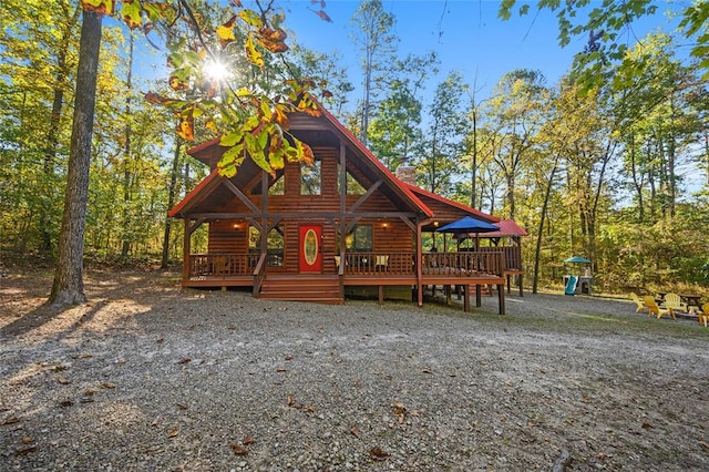 log cabin featuring a playground and a wooden deck