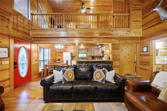 living room with hardwood / wood-style floors, wood walls, and a high ceiling