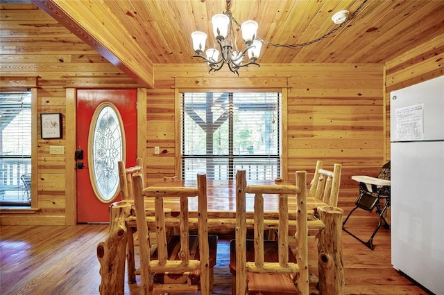 66 Lost Oaks Trl, Broken Bow, OK 74728 - dining space with a chandelier, wood ceiling, wood walls, and wood finished floors