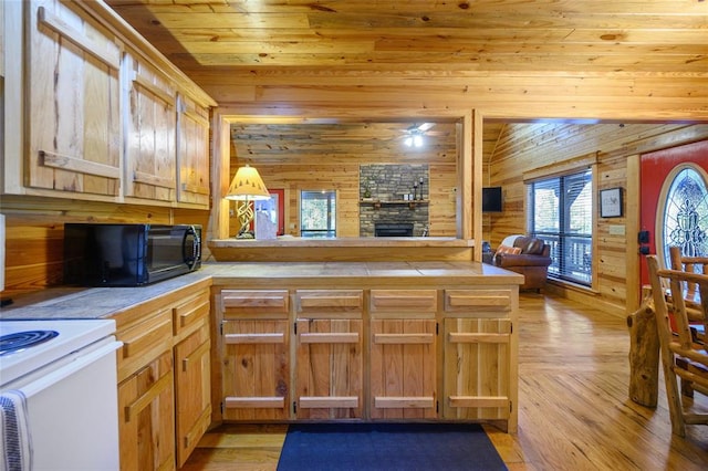 kitchen with kitchen peninsula, wood walls, pendant lighting, light hardwood / wood-style floors, and wood ceiling