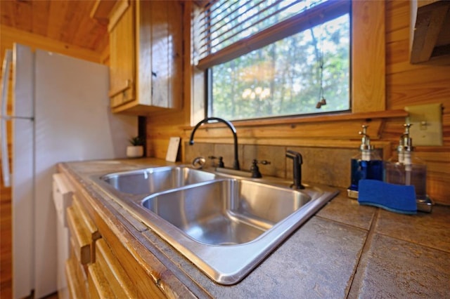 66 Lost Oaks Trl, Broken Bow, OK 74728 - kitchen with a sink, wood walls, and freestanding refrigerator
