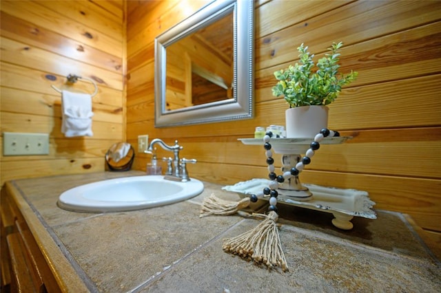 bathroom featuring vanity and wood walls