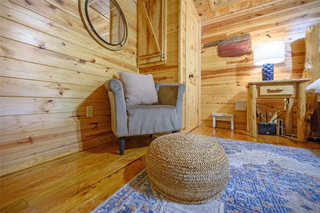 living area with wood walls and wood-type flooring