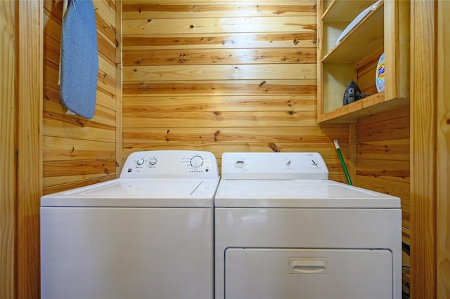 laundry area featuring washer and dryer and wooden walls