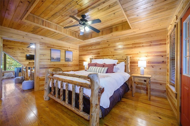 bedroom with wood-type flooring, wooden walls, ceiling fan, and wooden ceiling