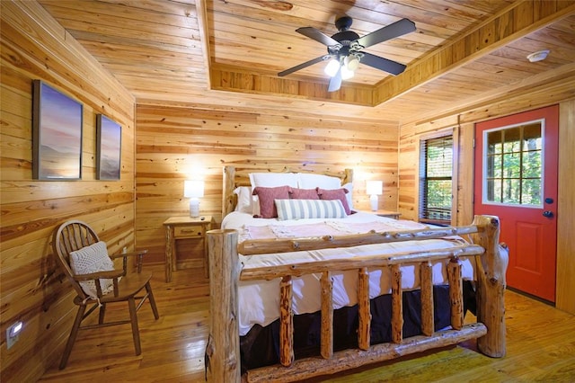 bedroom with hardwood / wood-style floors, ceiling fan, wood walls, and wooden ceiling