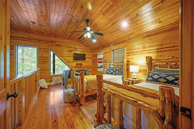 bedroom with wooden walls, light hardwood / wood-style flooring, wood ceiling, and lofted ceiling