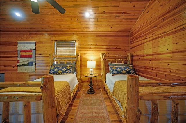 bedroom with wooden walls, hardwood / wood-style floors, wood ceiling, and lofted ceiling