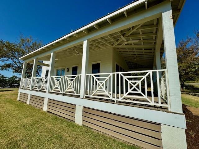 view of property exterior featuring covered porch and a yard