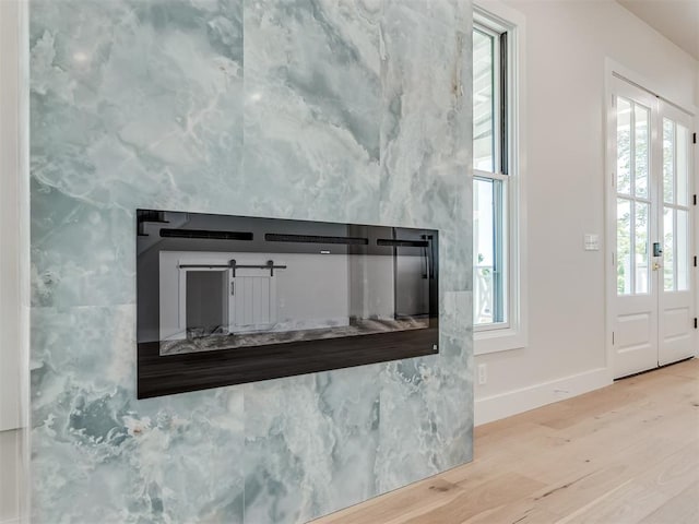 details featuring french doors, a barn door, and hardwood / wood-style flooring