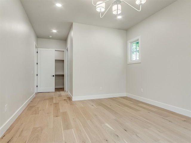 unfurnished room featuring light hardwood / wood-style flooring and a chandelier