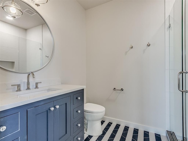 bathroom with tile patterned floors, vanity, an enclosed shower, and toilet