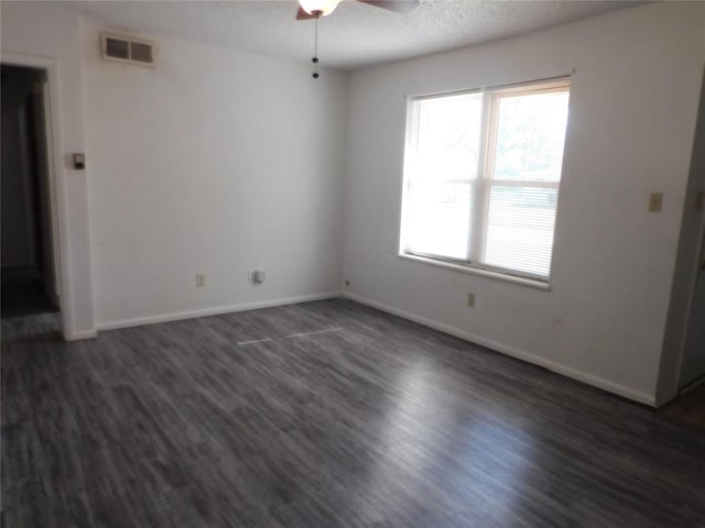 empty room featuring a textured ceiling, ceiling fan, and dark wood-type flooring