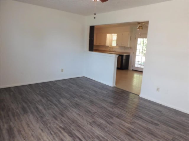 unfurnished room with ceiling fan, dark hardwood / wood-style flooring, and sink