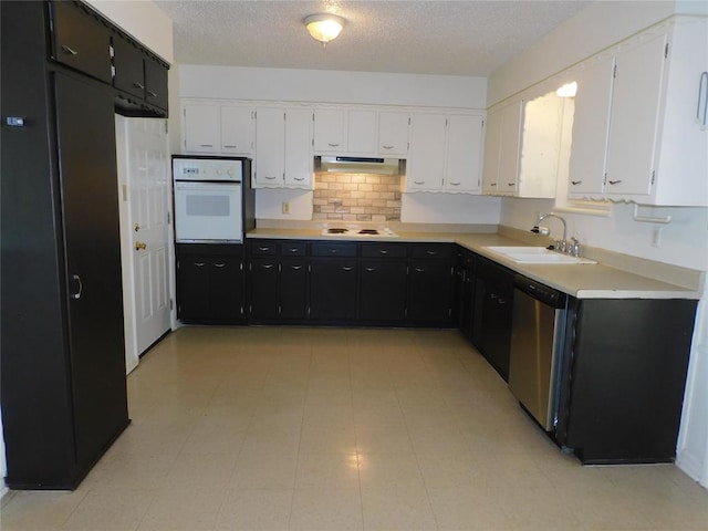 kitchen with a textured ceiling, white cabinetry, white appliances, and sink