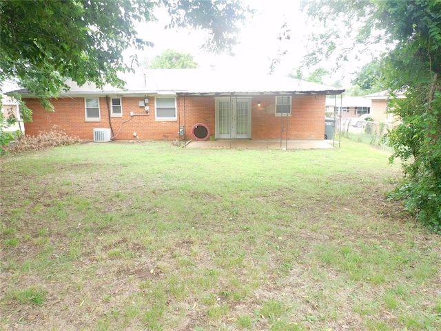 back of house featuring a patio area, a yard, cooling unit, and french doors