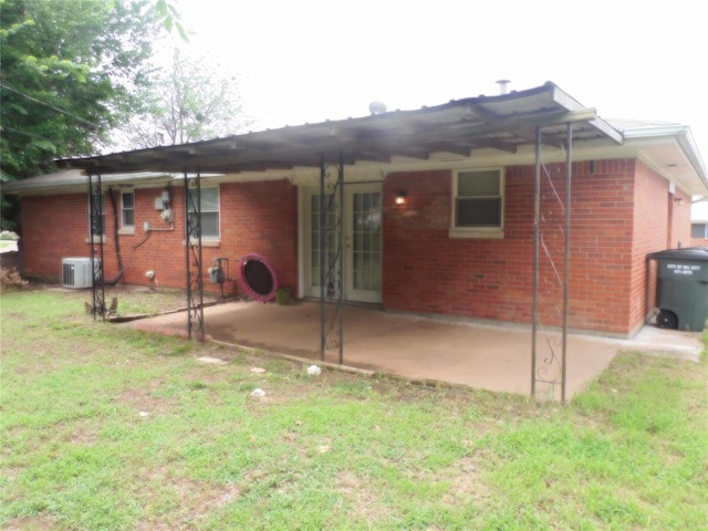 back of house featuring a lawn and a patio