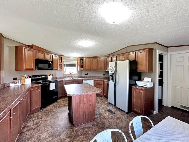 kitchen featuring a center island, black appliances, sink, vaulted ceiling, and a textured ceiling