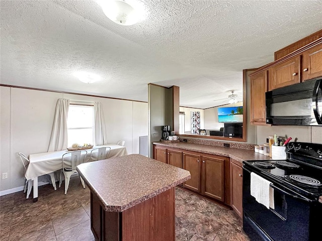 kitchen featuring a center island, black appliances, ceiling fan, a textured ceiling, and kitchen peninsula