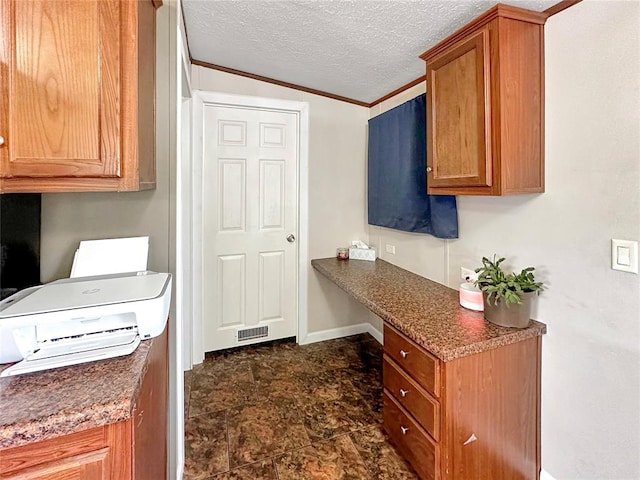 kitchen featuring lofted ceiling, crown molding, and a textured ceiling