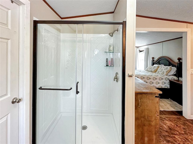 bathroom featuring a textured ceiling, crown molding, lofted ceiling, and walk in shower