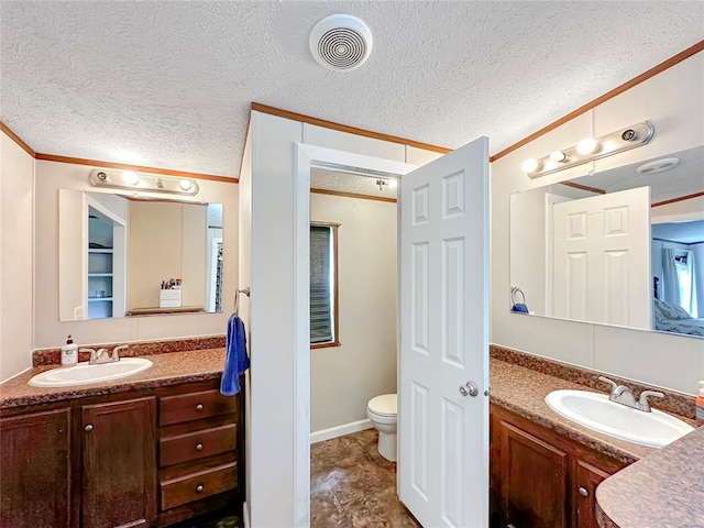 bathroom featuring crown molding, vanity, a textured ceiling, and toilet