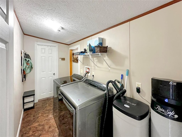 clothes washing area featuring tile patterned floors, washer and dryer, crown molding, and a textured ceiling