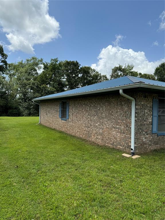 view of side of home featuring a lawn