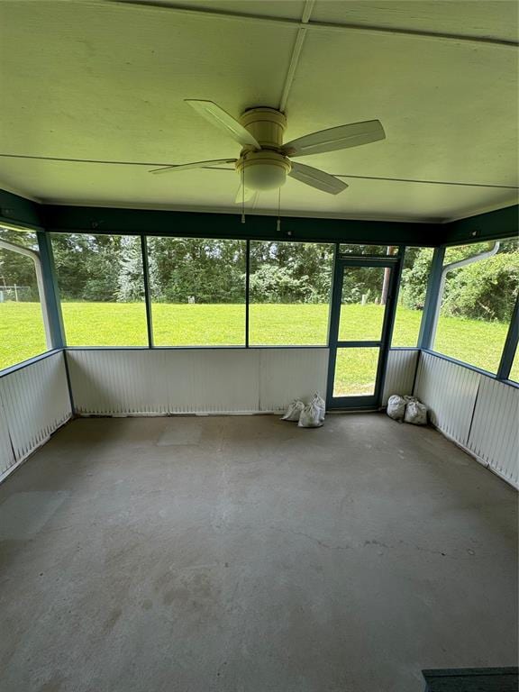 unfurnished sunroom with ceiling fan