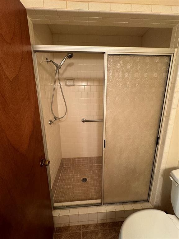 bathroom with toilet and a shower with shower door