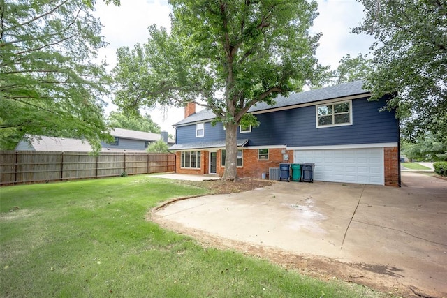 rear view of property featuring a yard, cooling unit, and a garage