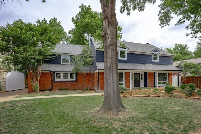 view of front of house featuring a front yard and a shed