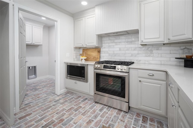 kitchen with tasteful backsplash, white cabinetry, and stainless steel appliances