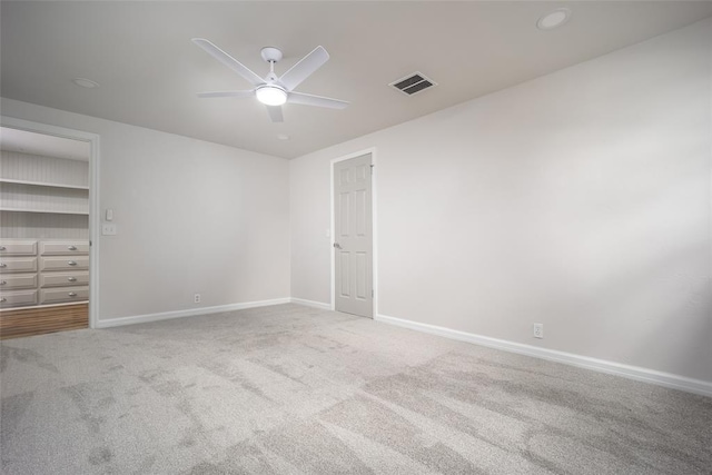 unfurnished bedroom with a closet, light colored carpet, and ceiling fan