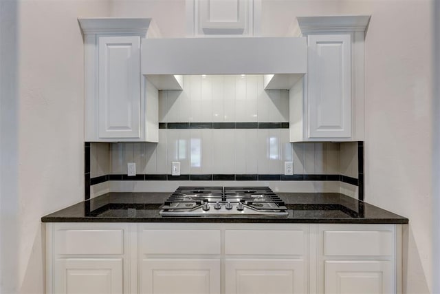 kitchen with white cabinets, decorative backsplash, and stainless steel gas stovetop