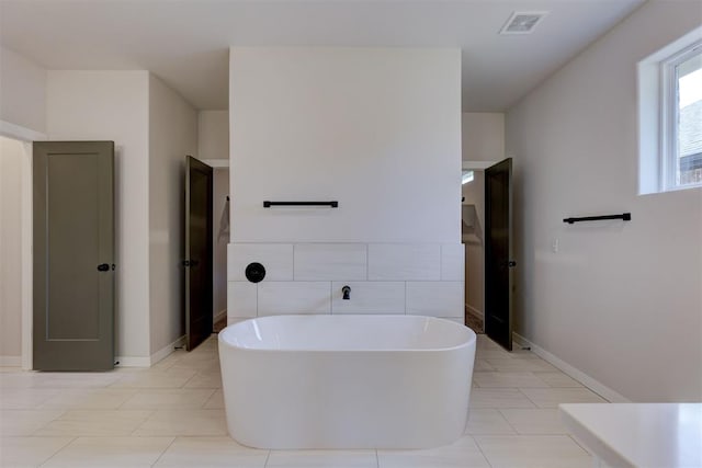 bathroom with tile patterned floors and a washtub