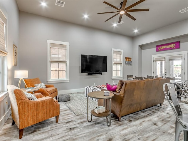 living room featuring french doors, light hardwood / wood-style floors, and ceiling fan