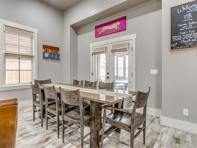 dining room with light hardwood / wood-style floors and french doors