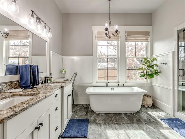 bathroom featuring shower with separate bathtub, vanity, a wealth of natural light, and a notable chandelier