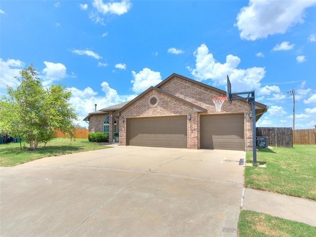 ranch-style home featuring a front yard, a garage, and central AC unit