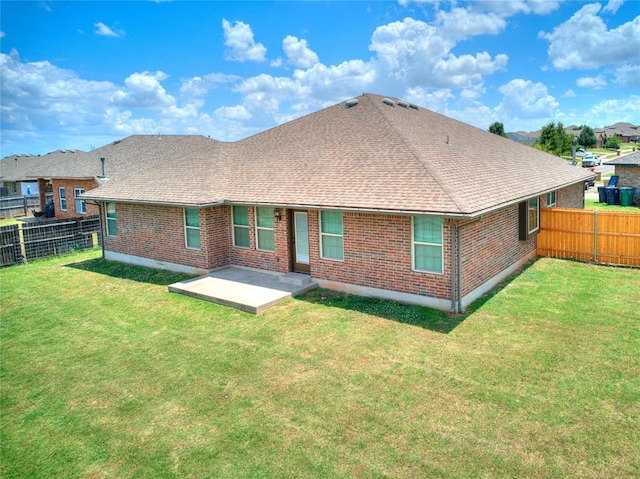 rear view of property featuring a lawn and a patio area