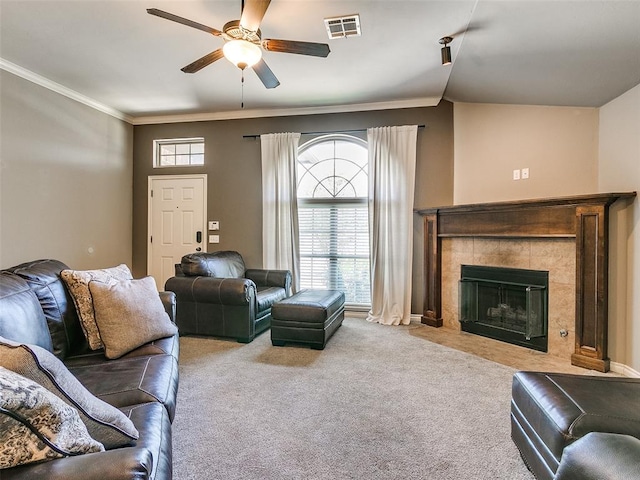 living room featuring ceiling fan, crown molding, light carpet, and a fireplace