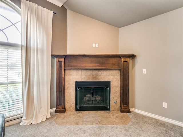 interior details featuring carpet and a tiled fireplace