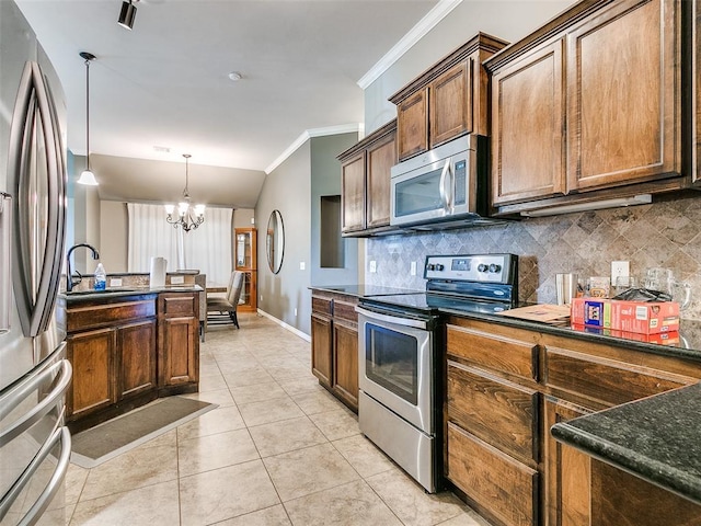 kitchen with backsplash, sink, hanging light fixtures, stainless steel appliances, and a chandelier