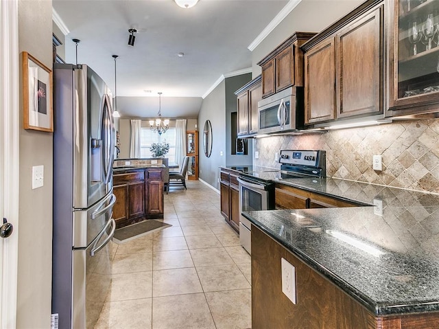 kitchen featuring tasteful backsplash, a notable chandelier, dark stone countertops, pendant lighting, and appliances with stainless steel finishes