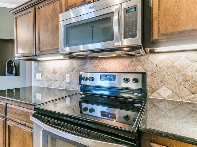 kitchen featuring decorative backsplash, dark stone counters, and stainless steel appliances