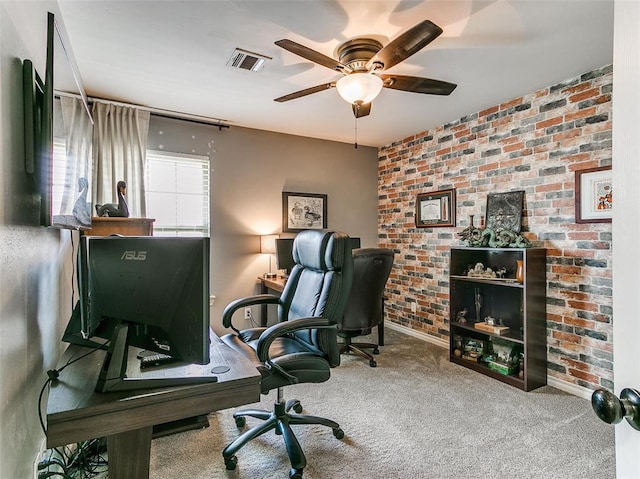 office area featuring carpet, ceiling fan, and brick wall