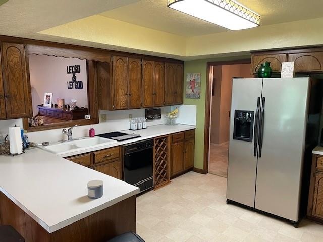 kitchen with kitchen peninsula, stainless steel refrigerator with ice dispenser, dark brown cabinets, sink, and black dishwasher